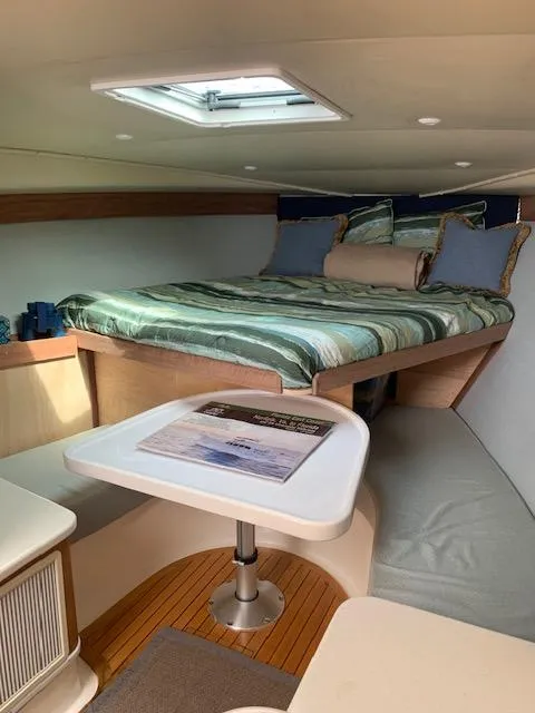Slide: The Image of Interior of 2004 Stolper 38 boat with cozy bed and table setup. - 10
