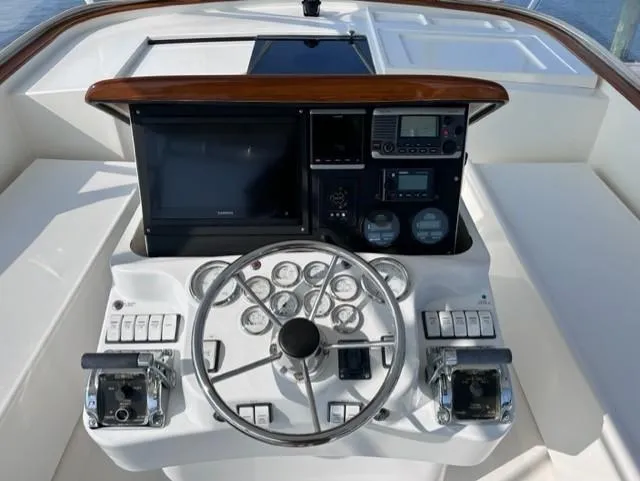 Slide: The Image of 2004 Stolper 38 boat helm with steering wheel, gauges, and navigation controls. - 18