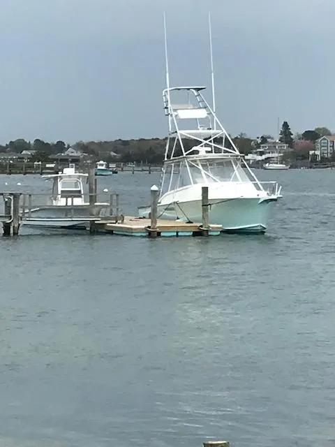 Slide: The Image of 2004 Stolper 38 boat docked on calm waters with a clear sky backdrop. - 24