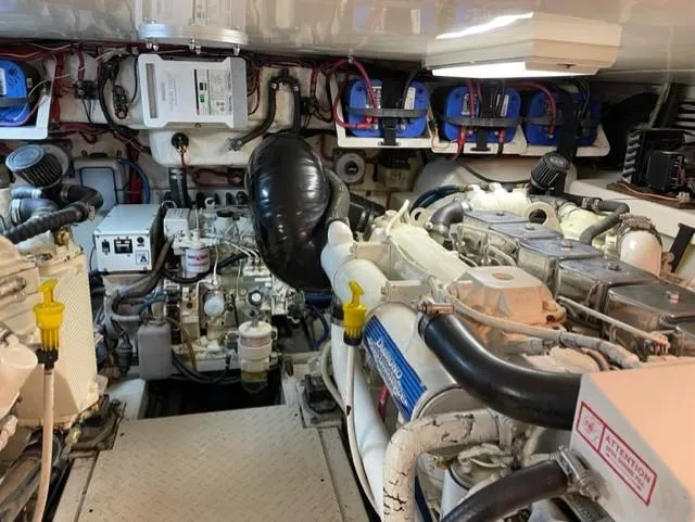 Slide: The Image of Engine room of a 2004 Stolper 38 boat, featuring dual engines and complex wiring. - 28