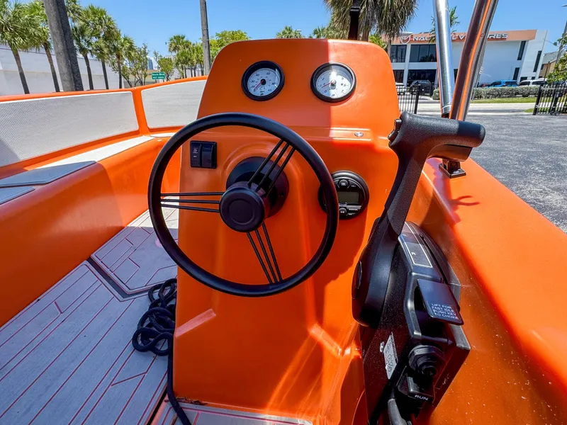Slide: The Image of 2024 Vision Marine Technologies Phantom boat cockpit with orange dashboard and steering wheel. - 4