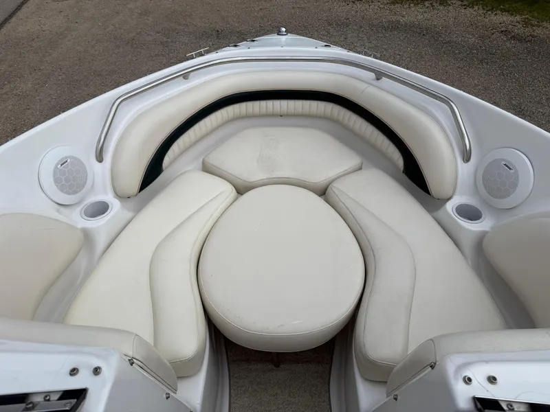 Slide: The Image of 1999 Chris-Craft 210 Bowrider interior with white cushioned seating and built-in speakers. - 10