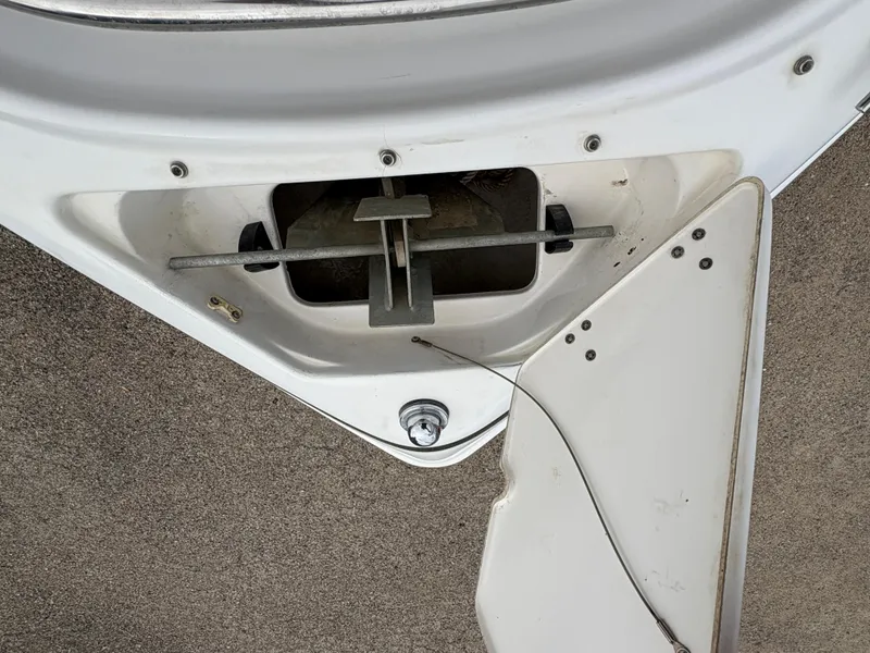 Slide: The Image of 1999 Chris-Craft 210 Bowrider anchor compartment with open hatch, showing anchor mechanism. - 13