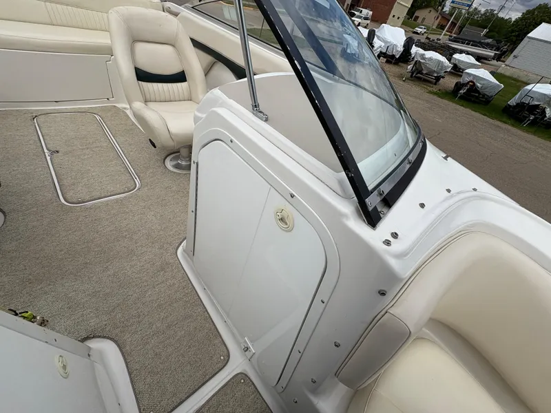 Slide: The Image of 1999 Chris-Craft 210 Bowrider interior with beige seating and carpeted flooring. - 15