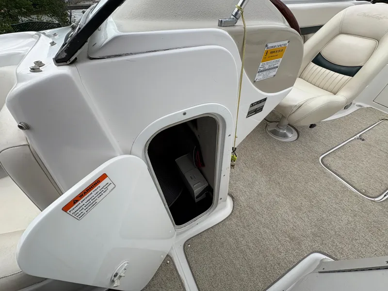Slide: The Image of 1999 Chris-Craft 210 Bowrider interior with open storage compartment and seating. - 16