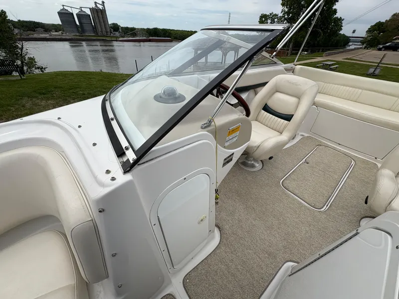 Slide: The Image of 1999 Chris-Craft 210 Bowrider interior with seating, steering wheel, and river view. - 18