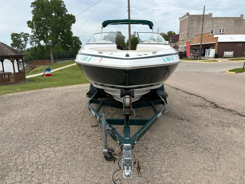Slide: The Image of 1999 Chris-Craft 210 Bowrider on trailer, parked in a rural area. - 2