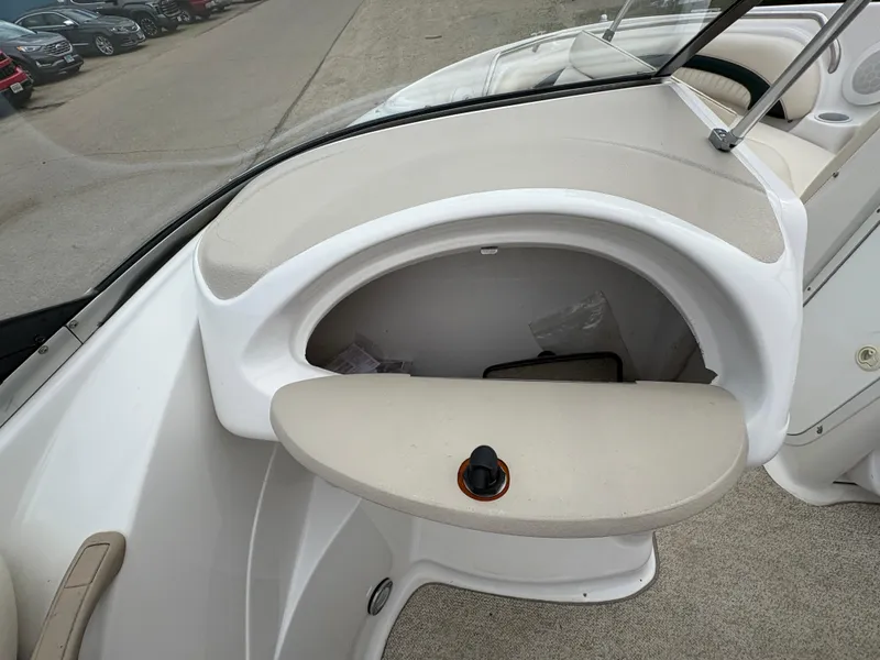 Slide: The Image of 1999 Chris-Craft 210 Bowrider interior, featuring a glove compartment and beige upholstery. - 22