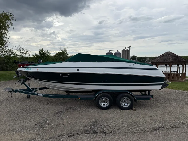 Slide: The Image of 1999 Chris-Craft 210 Bowrider boat on trailer, parked outdoors under cloudy sky. - 29