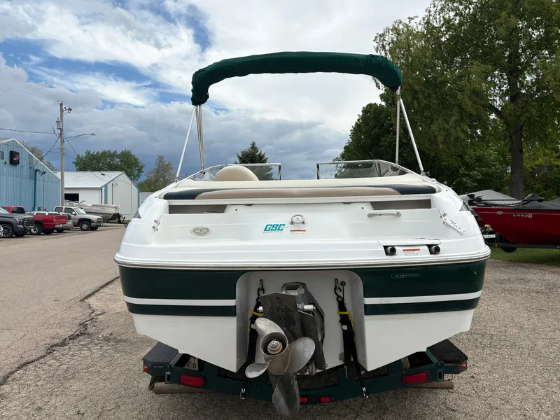 Slide: The Image of 1999 Chris-Craft 210 Bowrider boat, rear view, parked on a trailer, green and white design. - 6