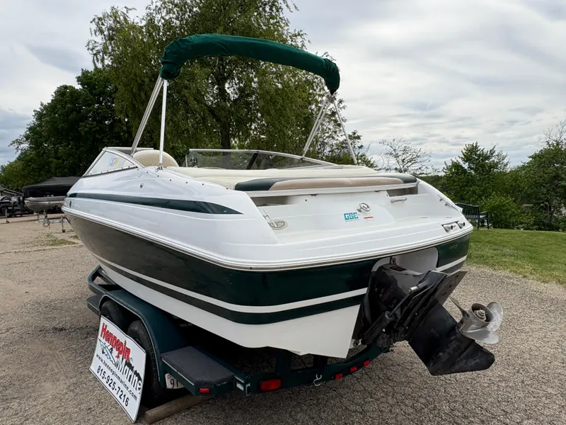 Slide: The Image of 1999 Chris-Craft 210 Bowrider boat on trailer, green and white exterior, parked outdoors. - 7