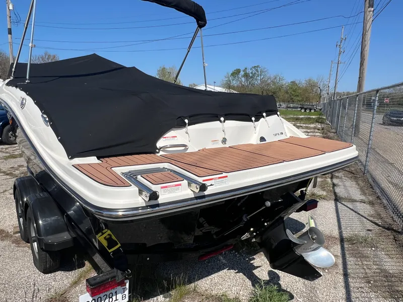 Slide: The Image of 2017 Sea Ray SPX 210 boat with black cover and trailer, parked outdoors. - 3