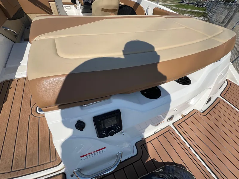 Slide: The Image of 2017 Sea Ray SPX 210 boat interior with tan seating and wood-style flooring. - 6