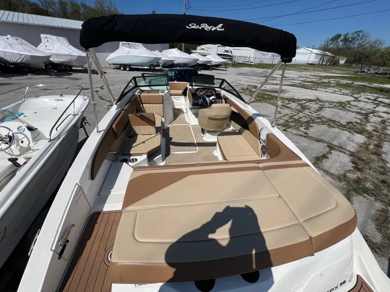 Slide: The Image of 2017 Sea Ray SPX 210 boat with tan seating and black canopy in a marina. - 7