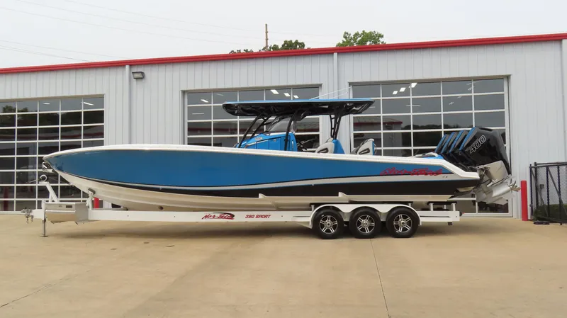 Slide: The Image of 2023 Nor-Tech 390 Sport Center Console boat on trailer outside a garage. - 0