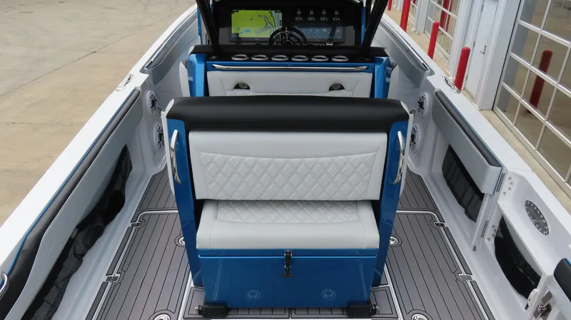 Slide: The Image of 2023 Nor-Tech 390 Sport Center Console interior with blue and white seating, modern dashboard. - 6