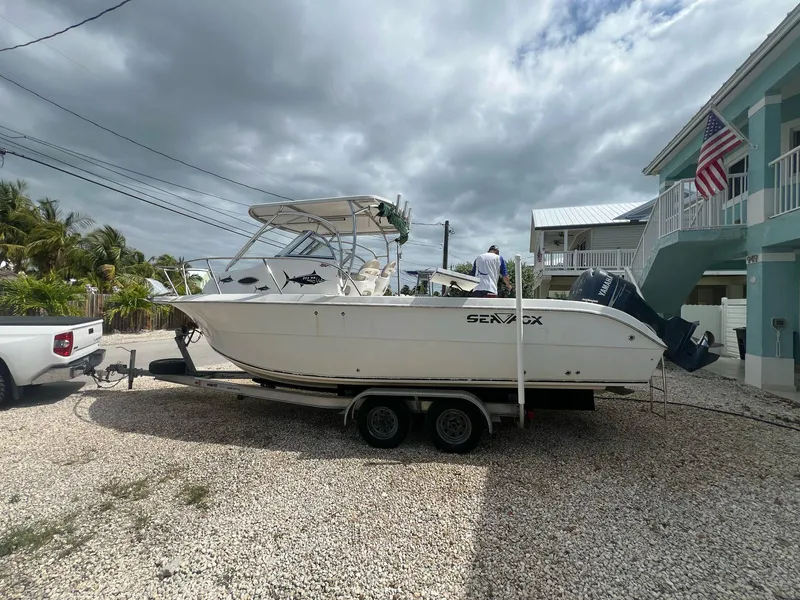 Slide: The Image of 2006 Sea Fox 257 Walk Around boat on trailer, parked in a residential driveway. - 0