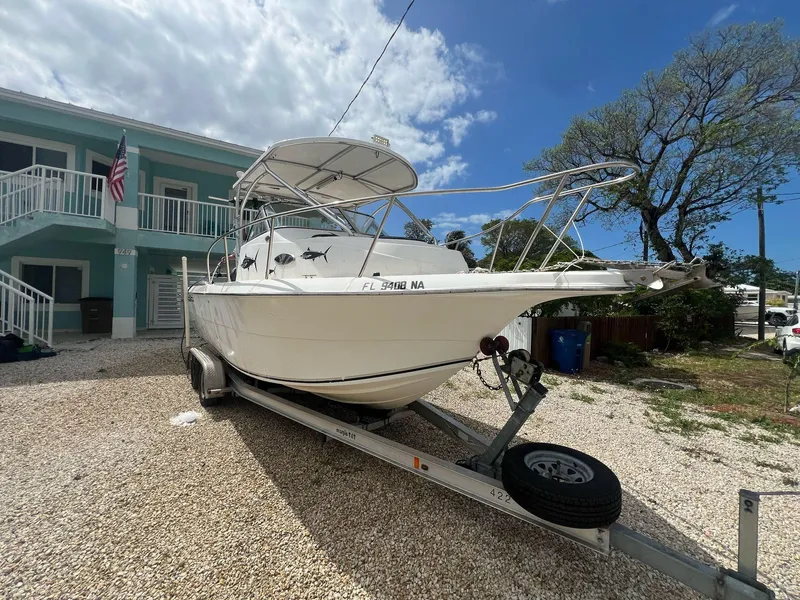 Slide: The Image of 2006 Sea Fox 257 Walk Around boat on trailer, parked in front of a house. - 1