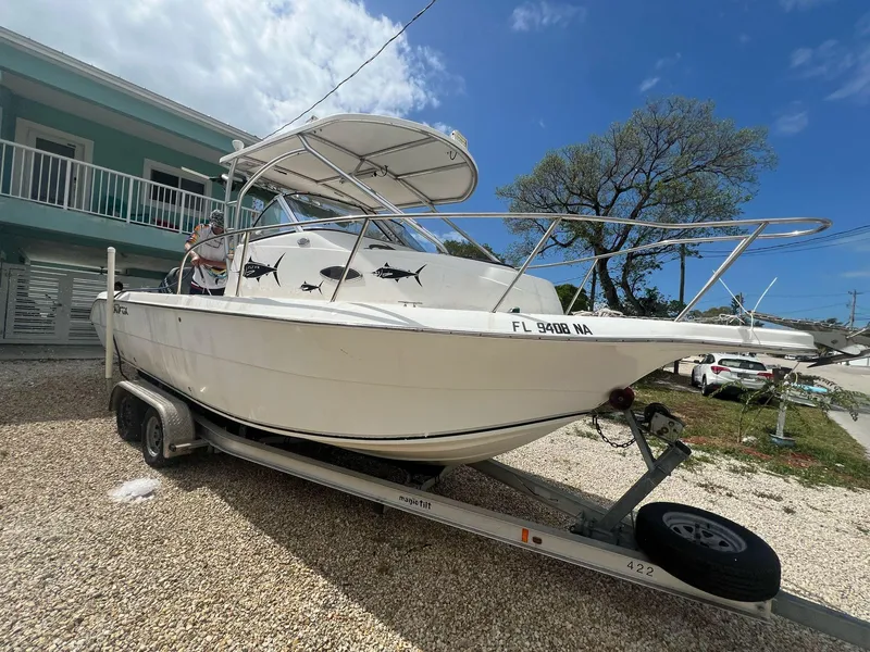 Slide: The Image of 2006 Sea Fox 257 Walk Around boat on trailer, parked outdoors under a clear sky. - 2