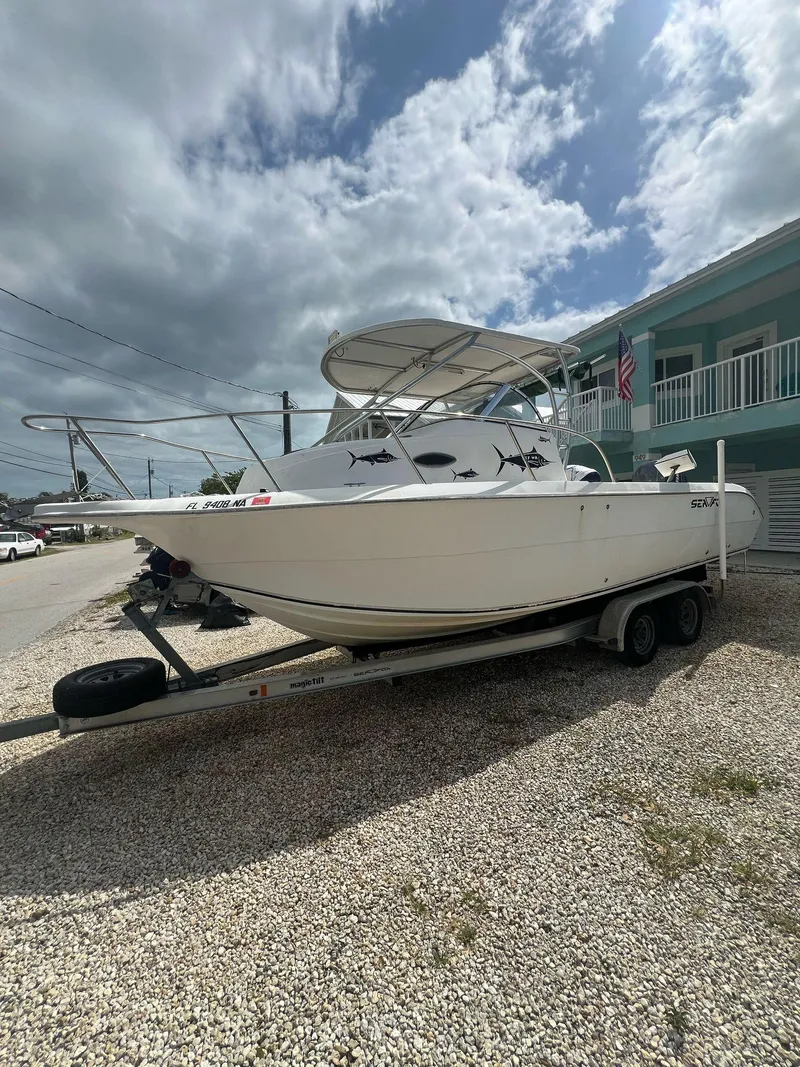 Slide: The Image of 2006 Sea Fox 257 Walk Around boat on trailer, parked outdoors under cloudy sky. - 5