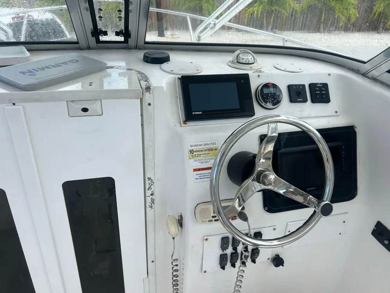 Slide: The Image of 2006 Sea Fox 257 Walk Around boat cockpit with steering wheel and navigation instruments. - 7