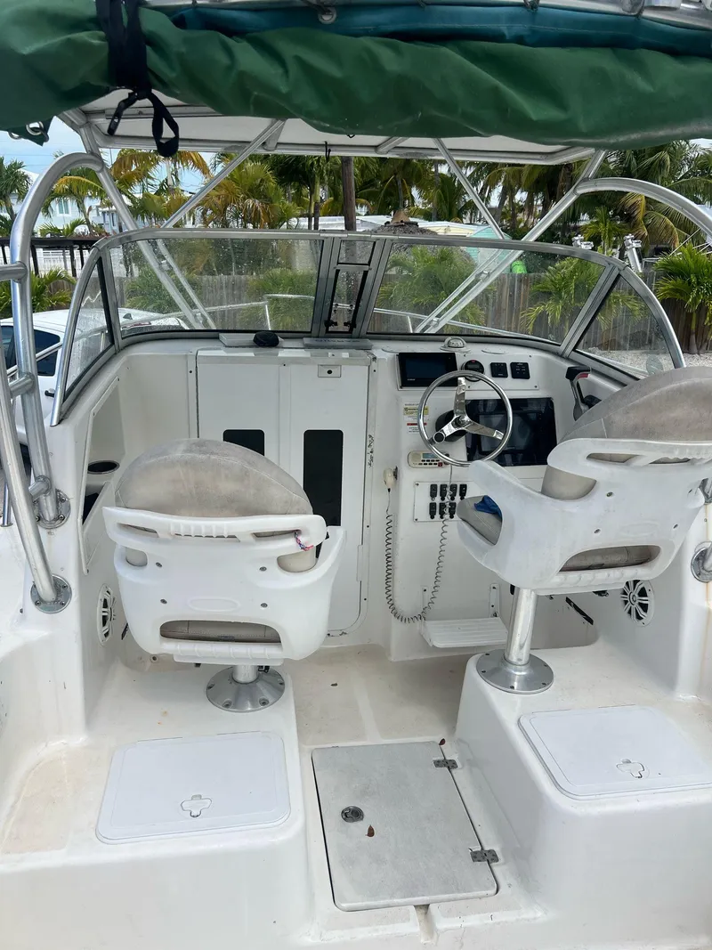 Slide: The Image of 2006 Sea Fox 257 Walk Around boat cockpit with dual seats and steering wheel. - 9