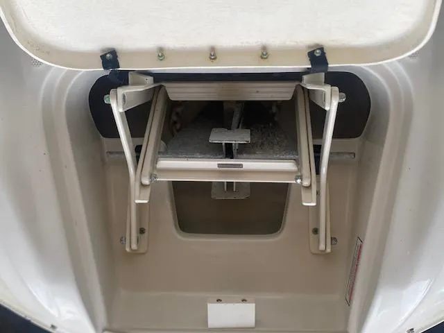 Slide: The Image of 2004 Sea Ray 240 Sundeck anchor storage compartment with open hatch and visible anchor. - 11