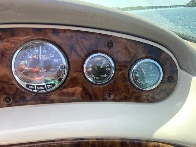 Slide: The Image of Dashboard of a 2004 Sea Ray 240 Sundeck boat with gauges and wood finish. - 14
