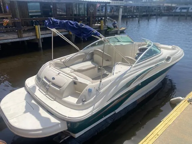 Slide: The Image of 2004 Sea Ray 240 Sundeck boat docked at marina, featuring sleek design and spacious seating. - 2
