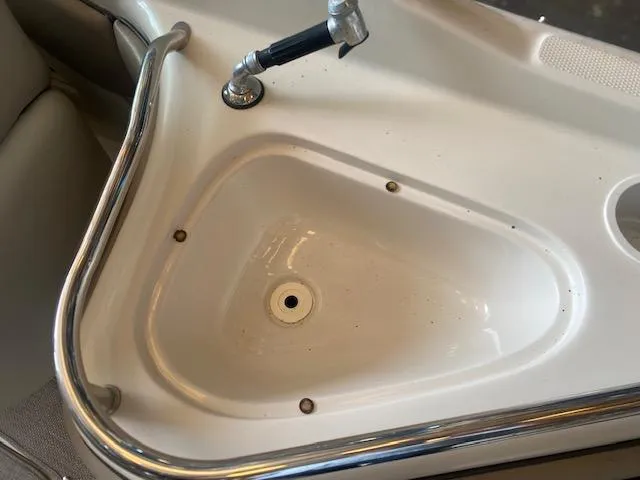 Slide: The Image of 2004 Sea Ray 240 Sundeck sink with faucet and stainless steel railing. - 23