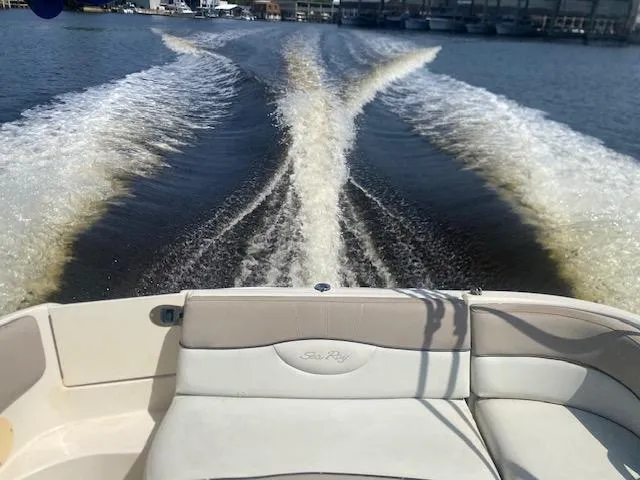 Slide: The Image of 2004 Sea Ray 240 Sundeck cruising, leaving a wake on the water. - 25