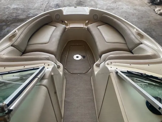 Slide: The Image of 2004 Sea Ray 240 Sundeck interior with beige seating and open windshield. - 7