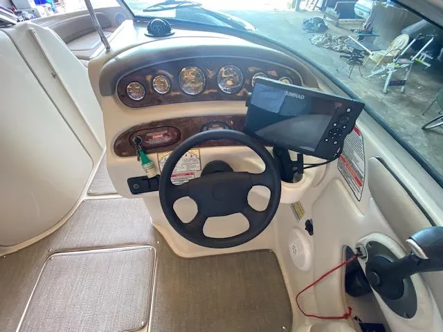 Slide: The Image of 2004 Sea Ray 240 Sundeck dashboard with steering wheel and navigation system. - 8