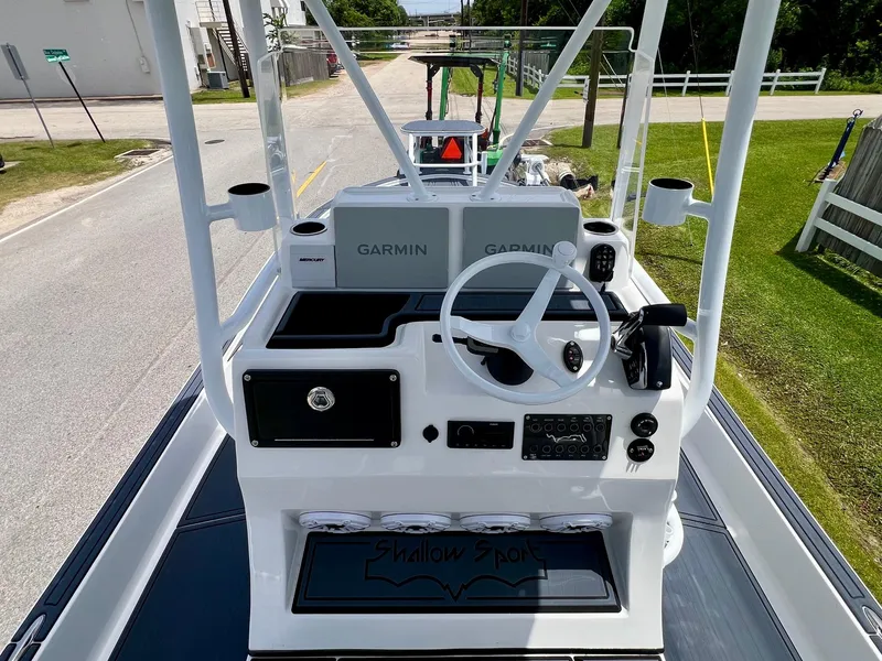 Slide: The Image of 2024 Shallow Sport 25 X3 boat console with Garmin navigation system, steering wheel, and cup holders. - 10