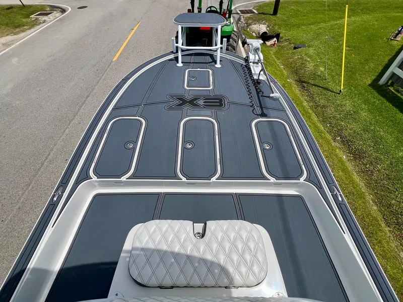 Slide: The Image of 2024 Shallow Sport 25 X3 boat deck with sleek design and storage compartments. - 14