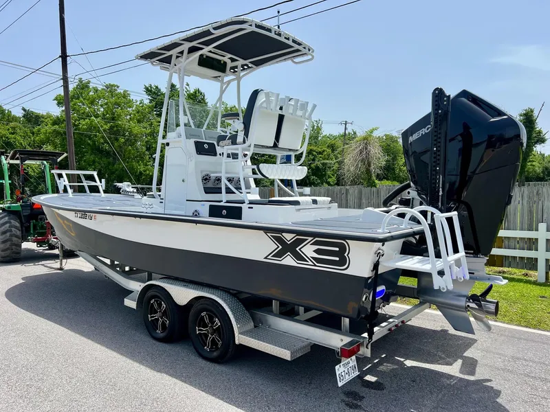 Slide: The Image of 2024 Shallow Sport 25 X3 boat on trailer, featuring sleek design and powerful engine. - 2