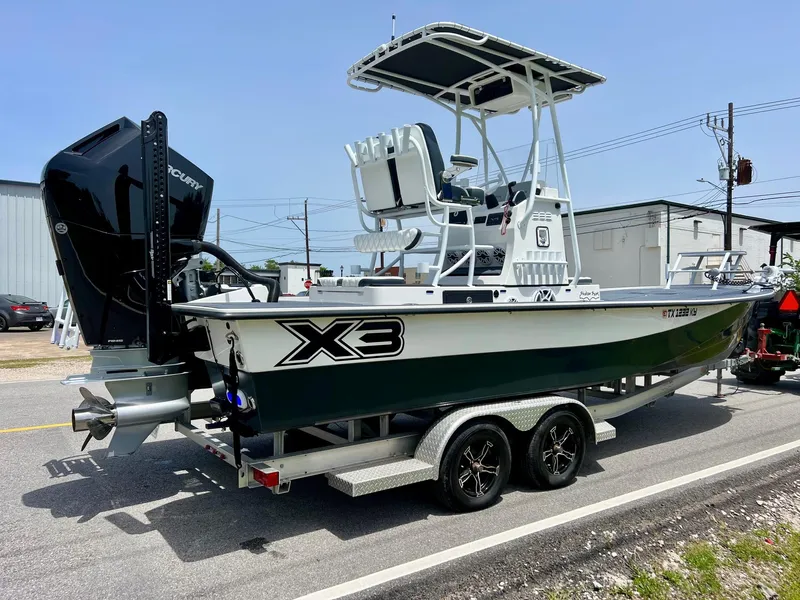 Slide: The Image of 2024 Shallow Sport 25 X3 boat on trailer, featuring sleek design and powerful outboard motor. - 4