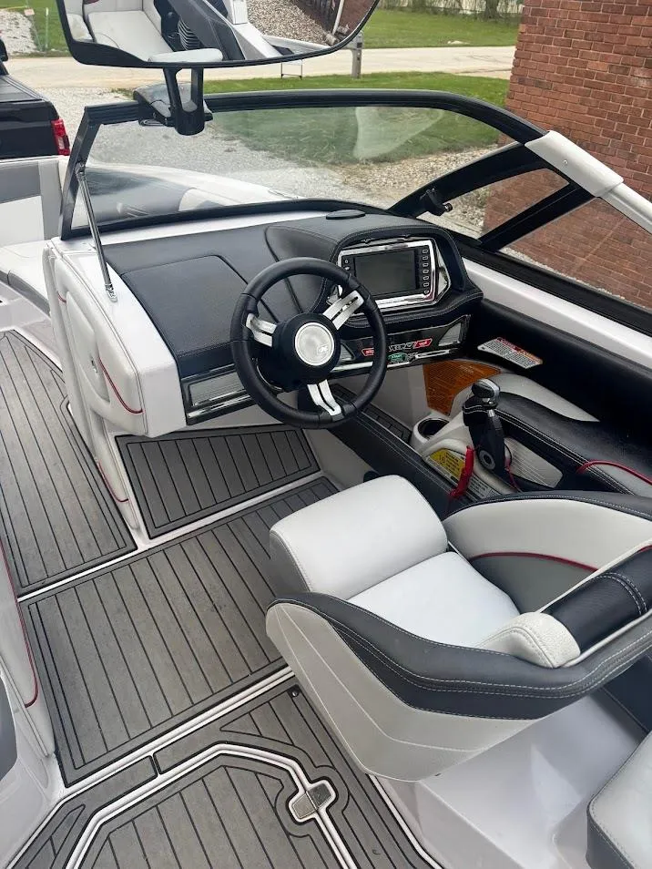 Slide: The Image of 2013 Nautique Super Air G23 boat interior with sleek dashboard and modern steering wheel. - 12