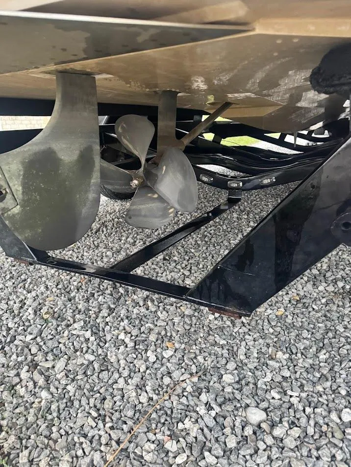 Slide: The Image of 2013 Nautique Super Air G23 boat propeller and rudder on gravel surface. - 20