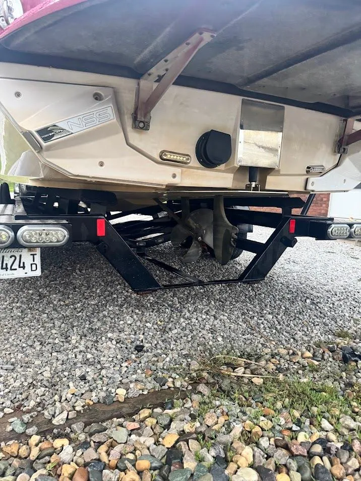Slide: The Image of 2013 Nautique Super Air G23 boat on trailer, rear view showing propeller and hull. - 21