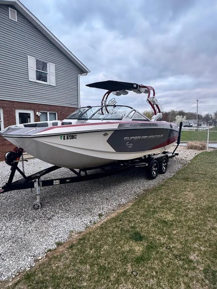 Slide: The Image of 2013 Nautique Super Air G23 boat on trailer, parked in residential driveway. - 8