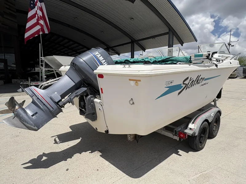 Slide: The Image of 1996 Pro-Line 202 boat interior with seating and steering console, docked outdoors. - 9