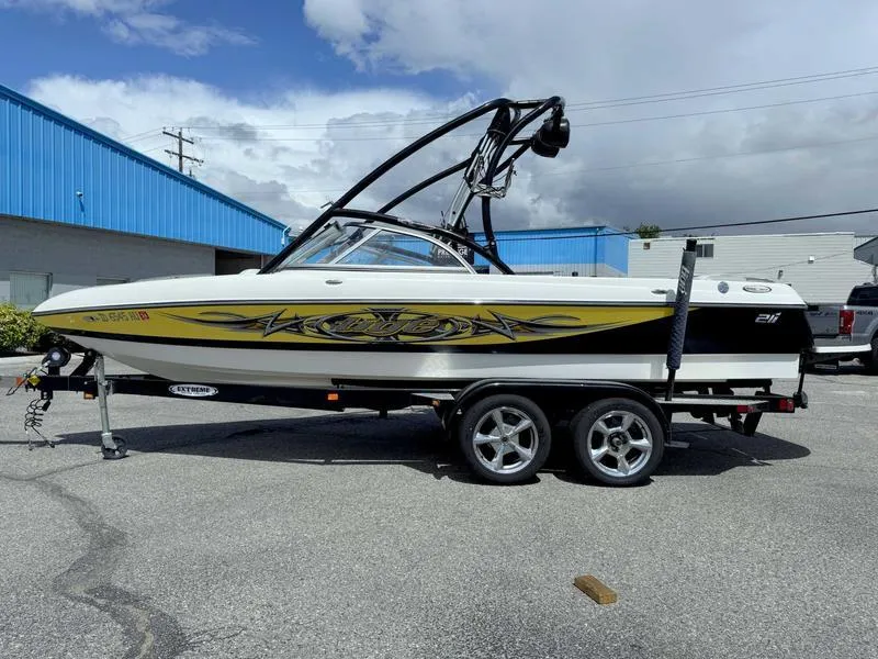 Slide: The Image of 2006 Tigé 21i boat with custom graphics on a trailer, parked outdoors. - 1