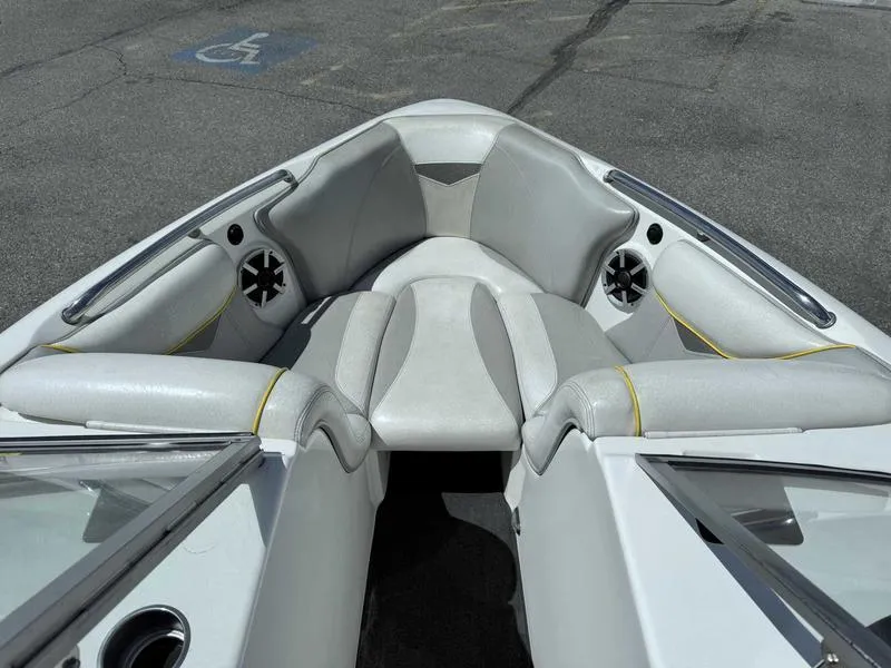 Slide: The Image of 2006 Tigé 21i boat interior with gray and white seating, speakers, and windshield. - 13