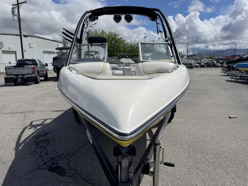 Slide: The Image of 2006 Tigé 21i boat on trailer, front view, parked outdoors under cloudy sky. - 3