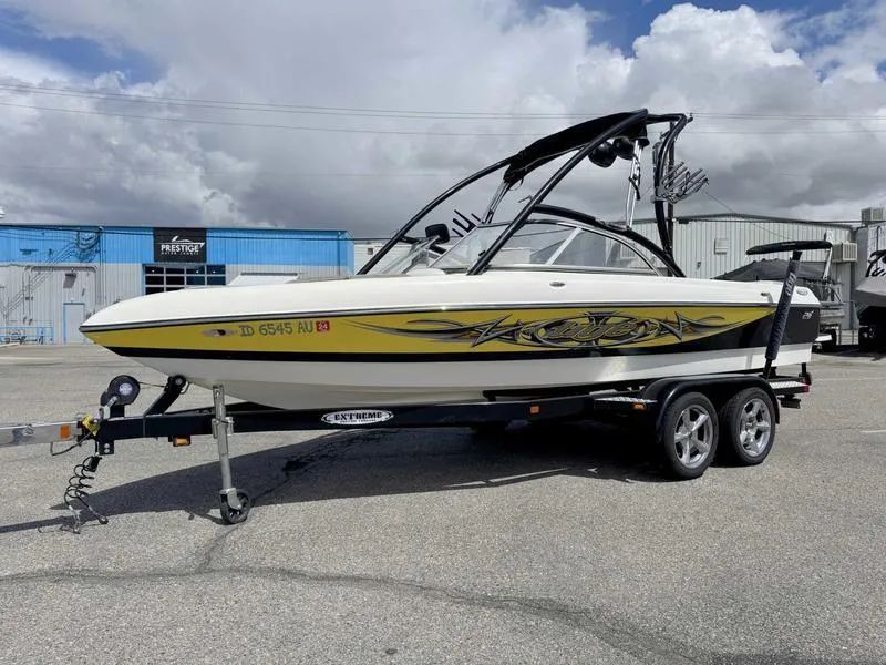 Slide: The Image of 2006 Tigé 21i boat on trailer, yellow and white design, parked outdoors. - 4