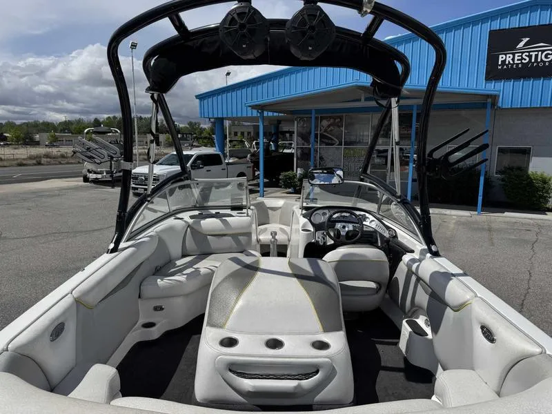Slide: The Image of 2006 Tigé 21i boat interior with seating and dashboard, parked at a dealership. - 7
