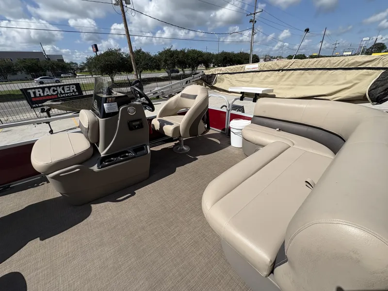 Slide: The Image of 2023 Sun Tracker Bass Buggy 16 XL pontoon boat interior with beige seating and steering console. - 11