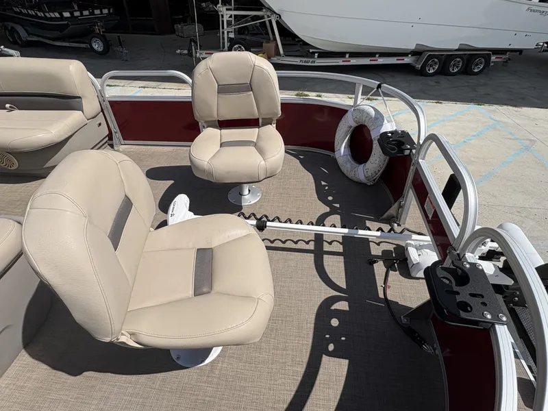 Slide: The Image of 2023 Sun Tracker Bass Buggy 16 XL pontoon boat interior with beige seating and fishing rod holders. - 8