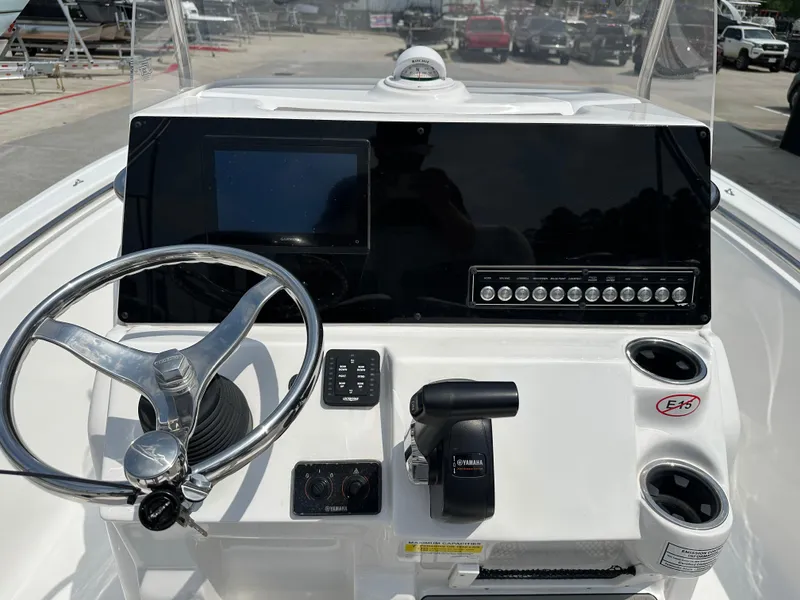 Slide: The Image of 2025 Tidewater 198CC boat dashboard with steering wheel, controls, and display screen. - 13